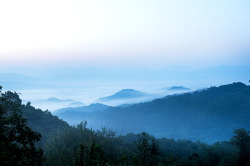 Panorama of sea of clouds around mountain peaks at dawn
