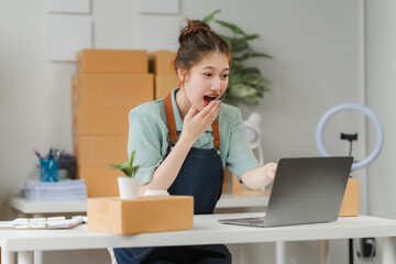 E-commerce Success: A young businesswoman is shocked and delighted by her online sales, with a...