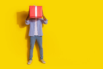 Full length photo of funky cool guy dressed checkered shirt holding big red present emtpy space isolated yellow color background