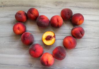 Peaches are laid out on the table in the shape of a heart. Flat lay