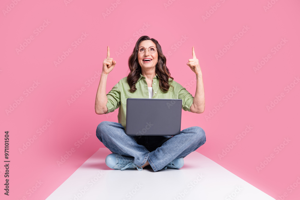 Wall mural Photo of experienced recruiter head retired lady in khaki shirt using laptop point fingers up vacancy budget isolated on pink color background