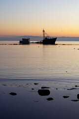 a sunken ship on a beach at sunset in Chile