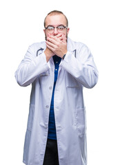 Fototapeta premium Young caucasian doctor man wearing medical white coat over isolated background shocked covering mouth with hands for mistake. Secret concept.