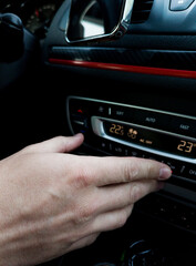 Male hand set the temperature in the car.