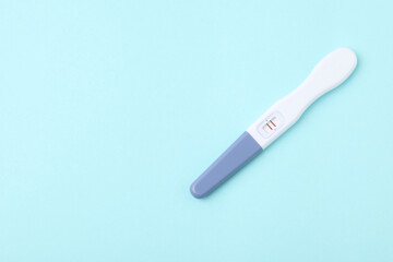 One pregnancy test on light blue background, top view. Space for text