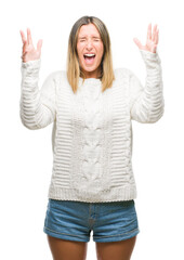 Young beautiful woman wearing winter sweater over isolated background celebrating mad and crazy for success with arms raised and closed eyes screaming excited. Winner concept