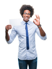 Afro american man holding blank card over isolated background doing ok sign with fingers, excellent symbol