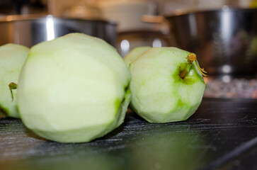 freshly peeled apple on a dark chopping board