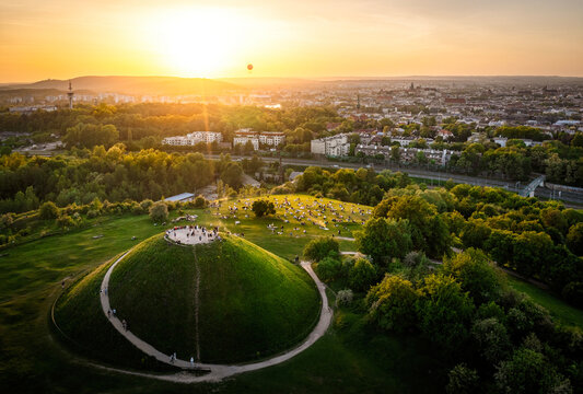 Sunset over Krakus Mound with people admiring the panorama of Krakow in Poland