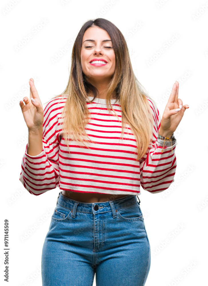 Sticker Young beautiful woman casual stripes winter sweater over isolated background smiling crossing fingers with hope and eyes closed. Luck and superstitious concept.