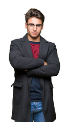 Young handsome elegant man wearing glasses over isolated background skeptic and nervous, disapproving expression on face with crossed arms. Negative person.