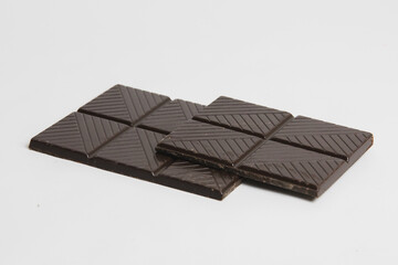 Photographie d'une tablette de chocolat noir cassée en deux.
