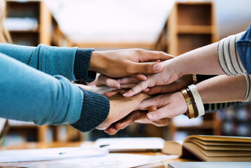 Hands, stack and group of students for learning, books or solidarity for goal, exam or education. People, huddle or scrum for motivation, trust or study for development in library, hall or university