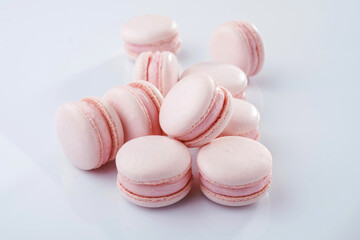 Pink colored. Bunch of macarons on the white surface