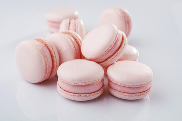 Pink colored. Bunch of macarons on the white surface