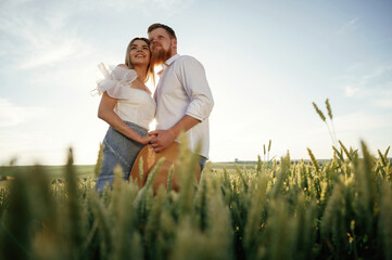 Closeness, embracing each other. Lovely couple are on the green agricultural field together