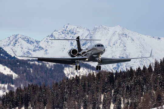 Business Jet landing in St. Moritz / Samedan Airport with mountains in the background