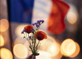 flag of france with bokeh and remembrance flowers