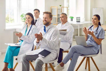 Positive team of doctors and nurses applauding during a hospital meeting, celebrating a moment of success in healthcare. Unity reflect the spirit of teamwork and excellence in medicare.