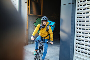 Delivery man biking through city street with a backpack