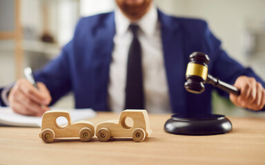 Car accident lawyer desk with toy wooden crashed autos, gavel, pay claims of injury, disability,...