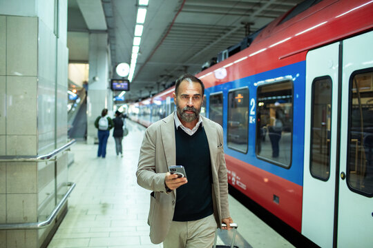 Businessman checking smartphone at the train station
