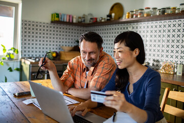 Couple managing finances online using credit card