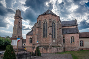 Fototapeta premium Étival-Clairefontaine, France - 09 01 2024: Saint-Pierre Abbey. Panoramic view outside of the back of the abbey and the war memorial.