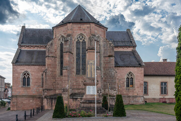 Fototapeta premium Étival-Clairefontaine, France - 09 01 2024: Saint-Pierre Abbey. Panoramic view outside of the back of the abbey and the war memorial.