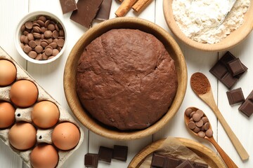 Chocolate dough and ingredients on white wooden table, flat lay