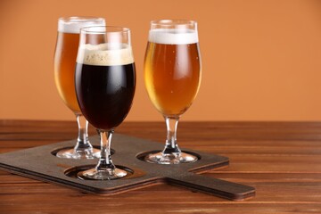 Glasses with different types of beer on wooden table