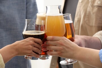People with different types of beer clinking glasses, closeup