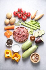 Cooking stew. Uncooked meat and vegetables on light grey table, flat lay