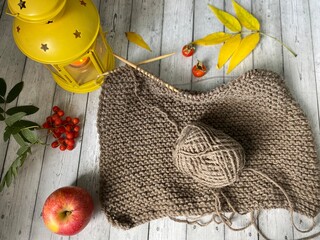 Knitted thing and needles and candle flashlight with autumn objects cozy fall season photo 