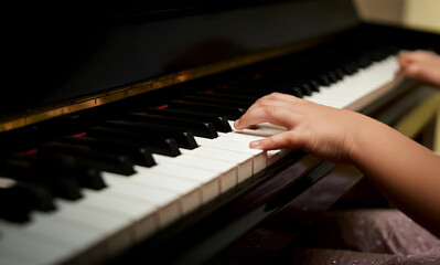 Close-up of a child playing the piano.