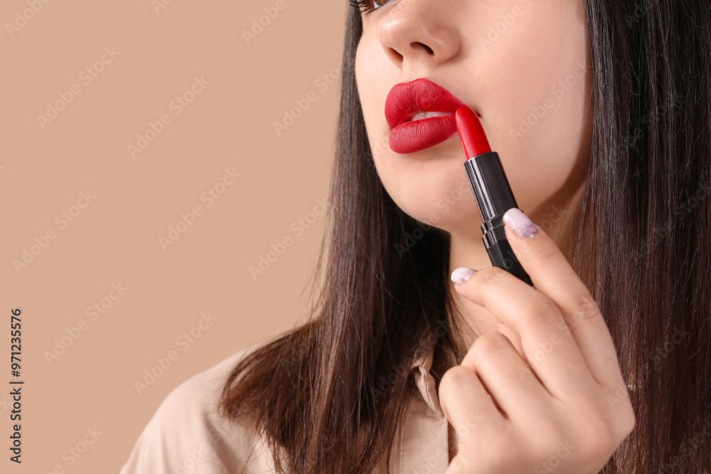 Sticker Young woman with red lips and lipstick on brown background, closeup