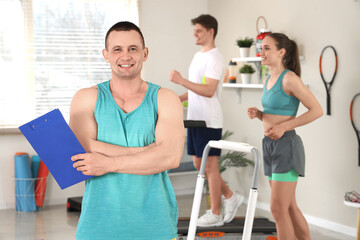 Male coach with clipboard in gym