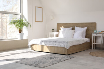 Cozy bed, plaid and bedside table in stylish bedroom