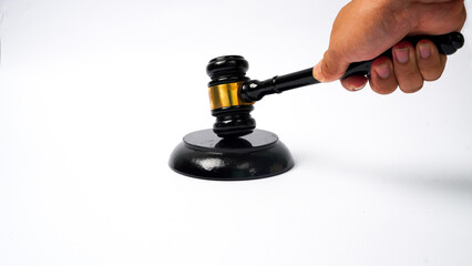 close-up of hand holding hammer while making decision isolated on white background. Auction hammer with wooden stand. Concept of law and justice.