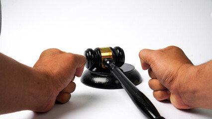 close-up of judge's wooden gavel on table and hand gesture hitting the table isolated on white background. Auction gavel with wooden stand. Angry concept of accepting law and justice.