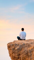 Person sitting on a cliff at dawn, contemplating new possibilities