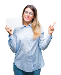 Young beautiful business woman holding blank card over isolated background very happy pointing with hand and finger to the side