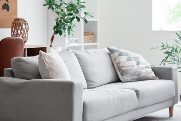 Comfortable sofa with pillows in cozy living room
