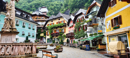 A charming town square in Hallstatt, Austria, with vibrant, colorful buildings adorned with balconies and flowers. The peaceful atmosphere of this UNESCO World Heritage village offers a glimpse into t