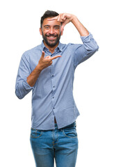 Adult hispanic man over isolated background smiling making frame with hands and fingers with happy face. Creativity and photography concept.