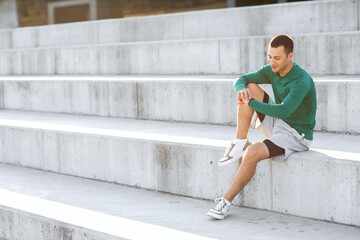 Sporty young man looking at watch outdoors