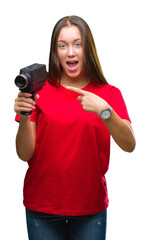 Young beautiful caucasian woman filming using vintage video camera over isolated background very happy pointing with hand and finger