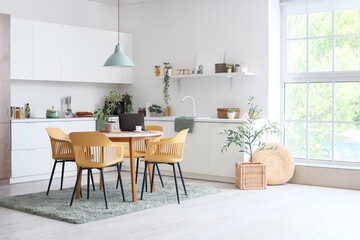 Interior of light dining room with table, chairs and white counters