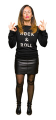 Beautiful middle age woman wearing rock and roll sweater relax and smiling with eyes closed doing...