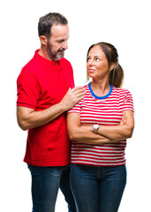 Fototapeta premium Middle age hispanic couple in love over isolated background with serious expression on face. Simple and natural looking at the camera.